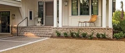 Brick house skirt along the foundation of a white farmhouse
