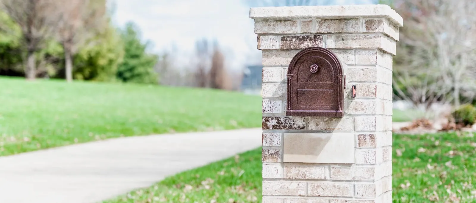 Brick and stone mailbox column beside a driveway